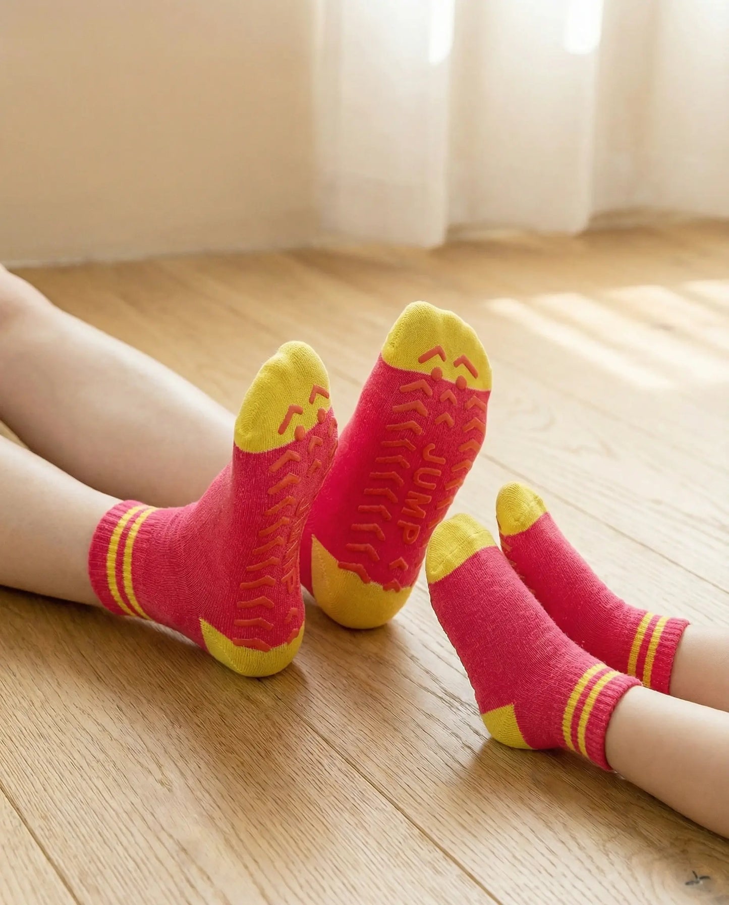 Tryon of bold jump family grip sock in pink colour on wooden floor