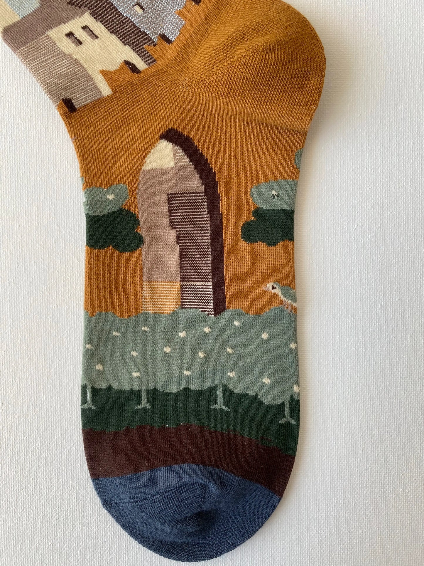 Close up of painted lost city unisex crew sock toe by Sock the Luck up AU