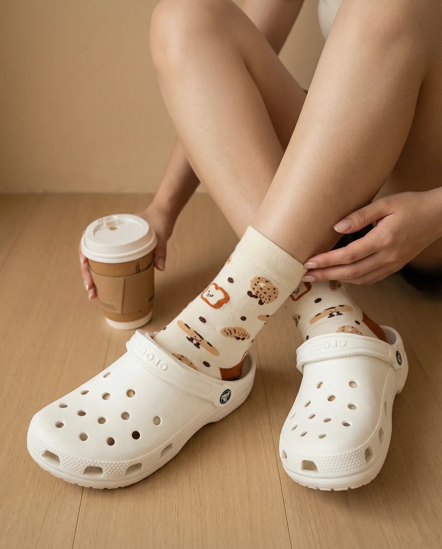 Closeup of pastry delight crew sock try-on with white Crocs clogs top view