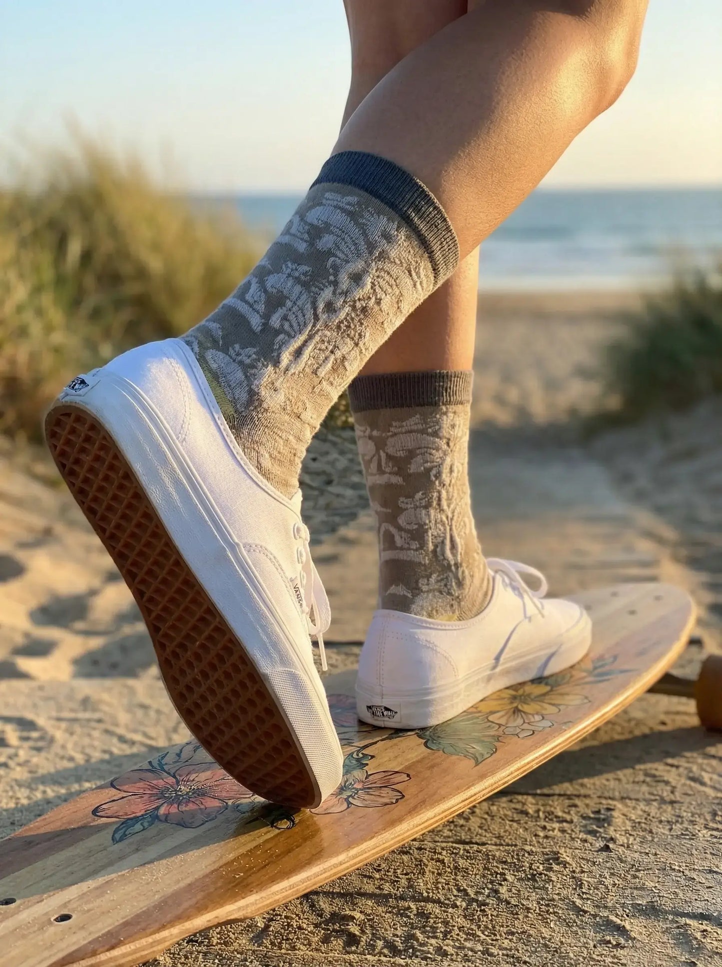 Close-up of taupe jacquard crew sock with white sneakers back view on skateboard at the beach