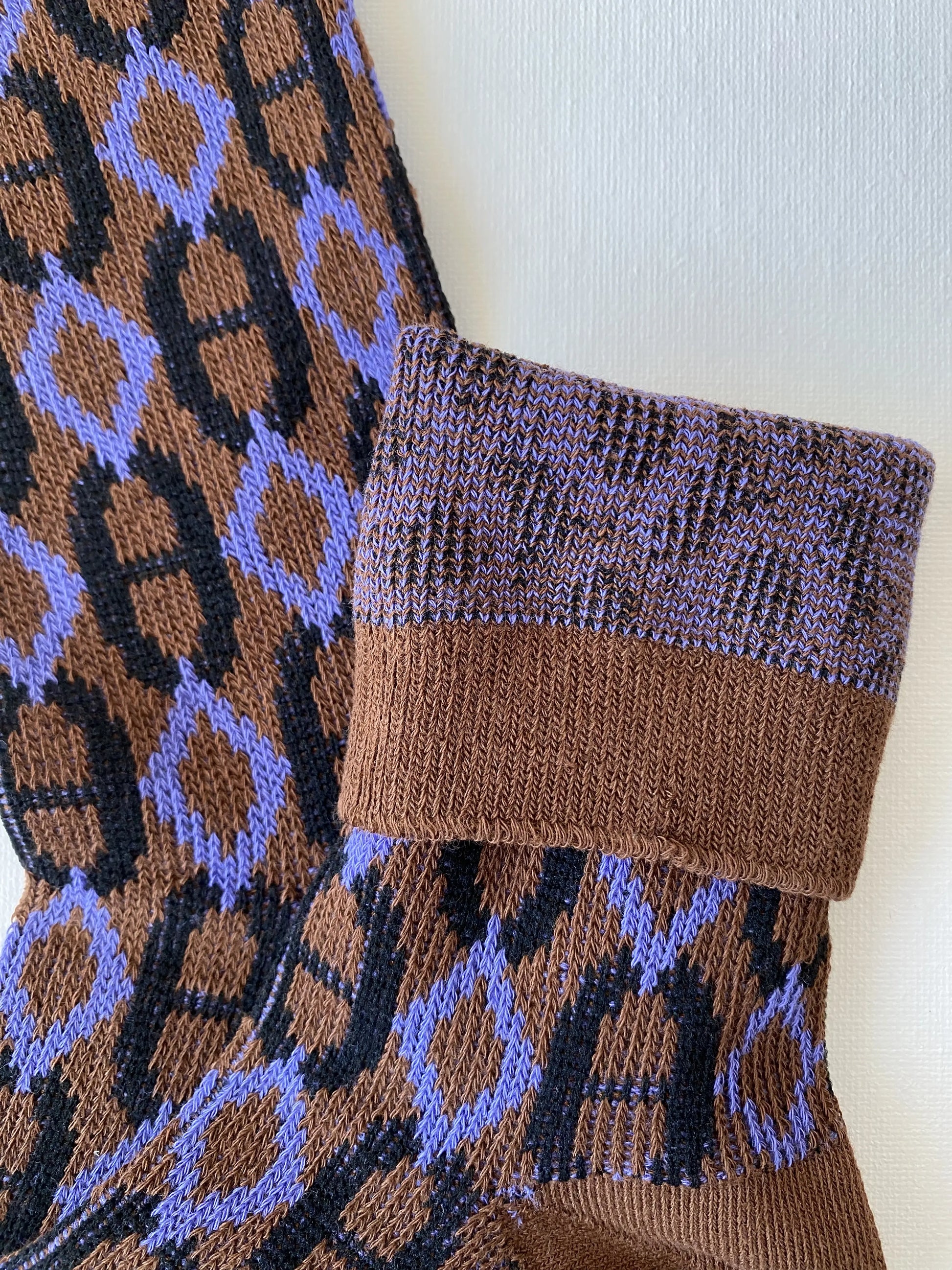 Closeup of the cuff and double knit construction of the heritage diamond crew sock in brown and purple colours 