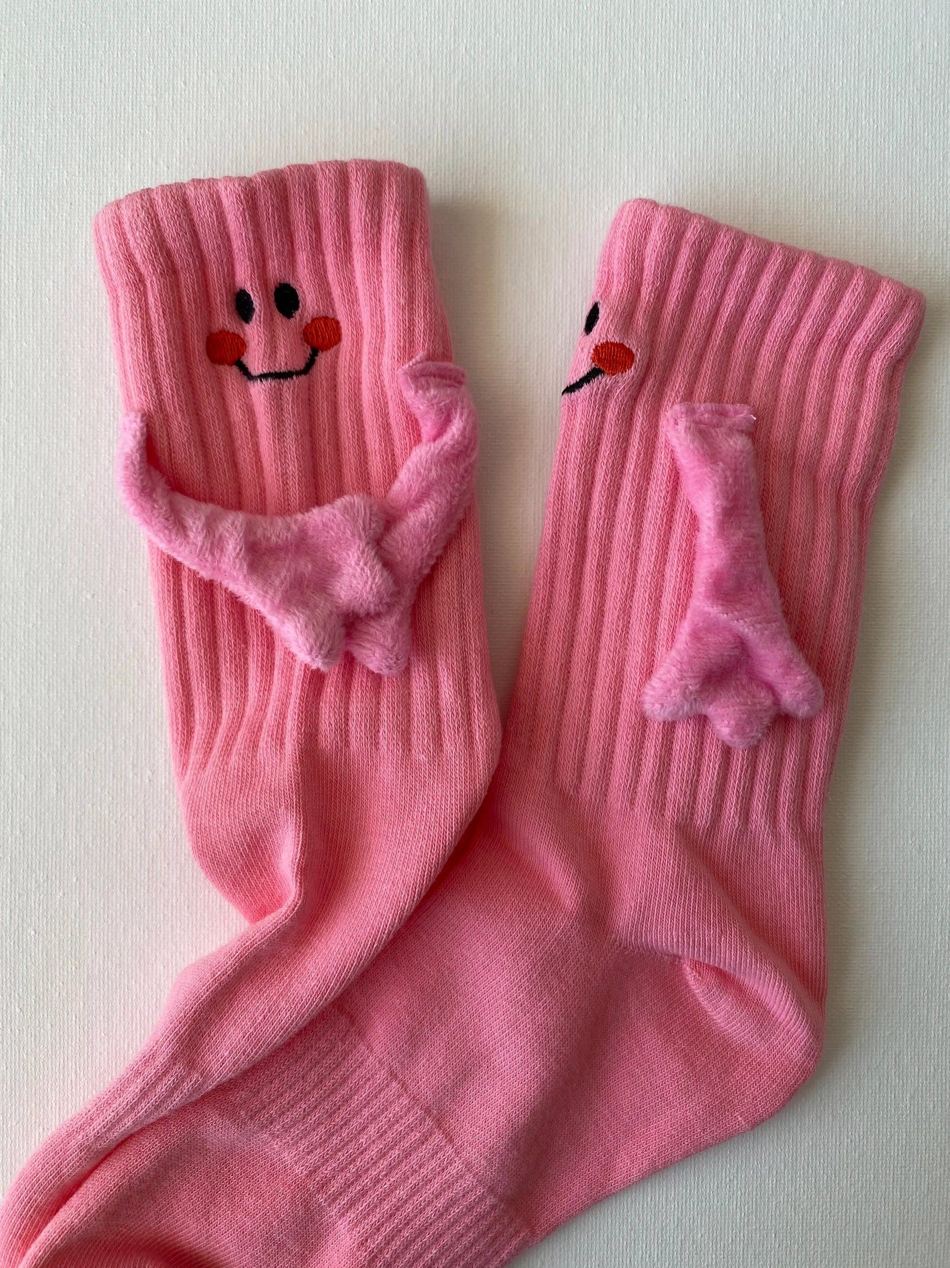 Closeup of magnetic smiley face family crew sock in pink colour adult size front view