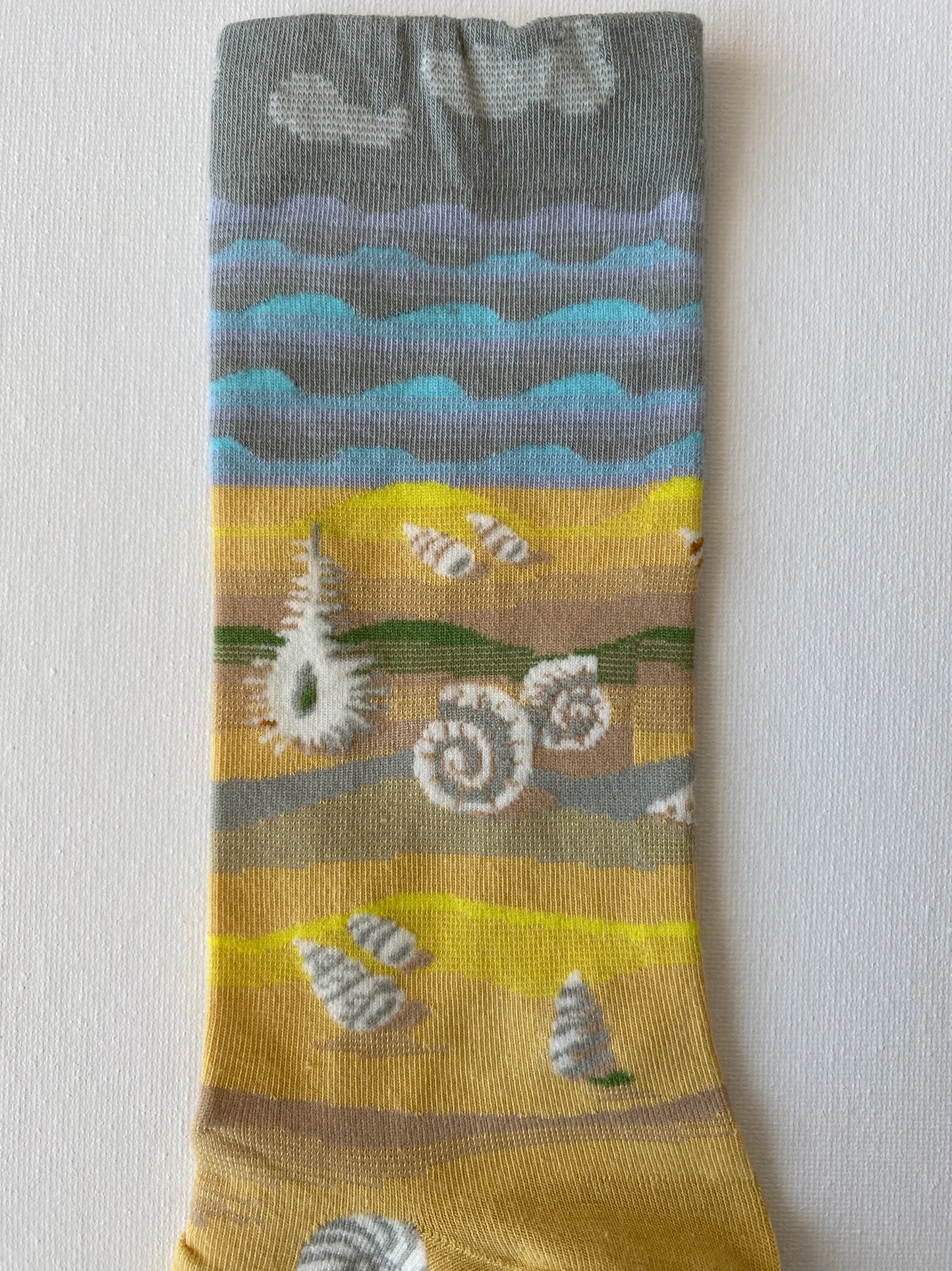 Close up of painted shells unisex crew sock leg by Sock the Luck up AU