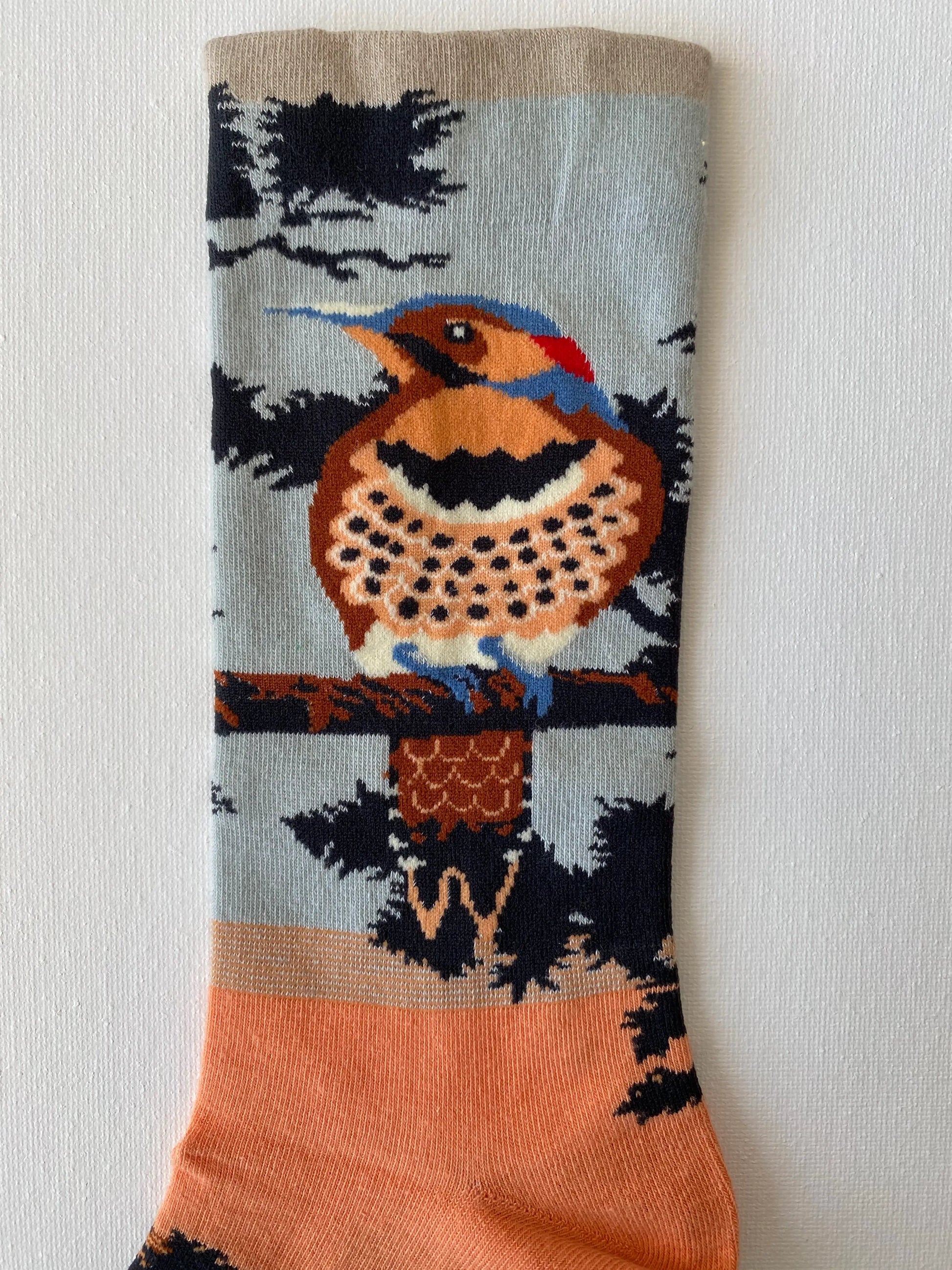 Close up of painted songbird unisex crew sock leg by Sock the Luck up AU