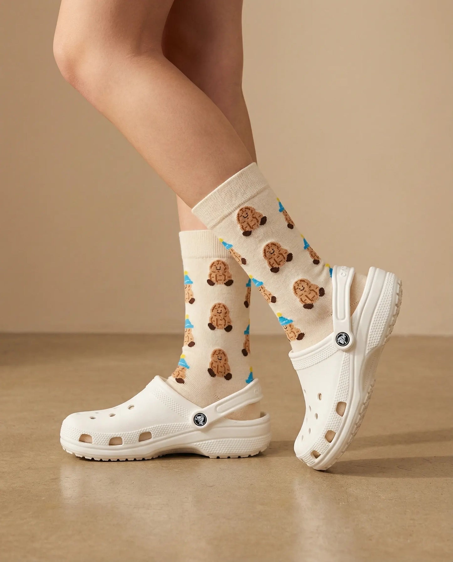Closeup of peanut character crew sock  with white Crocs clogs side view