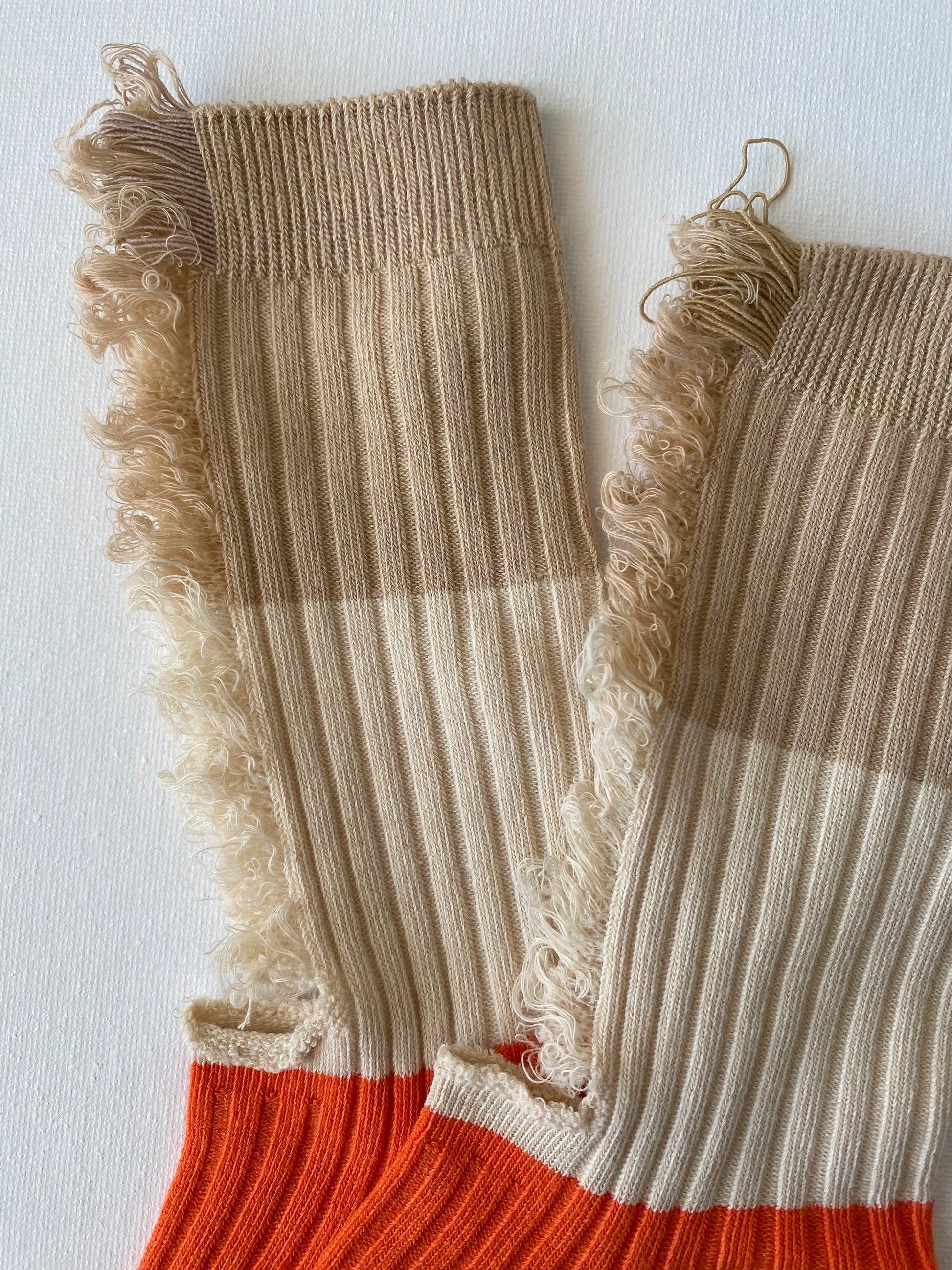 Closeup of unisex crew sock in cream and orange colour leg and cuff 