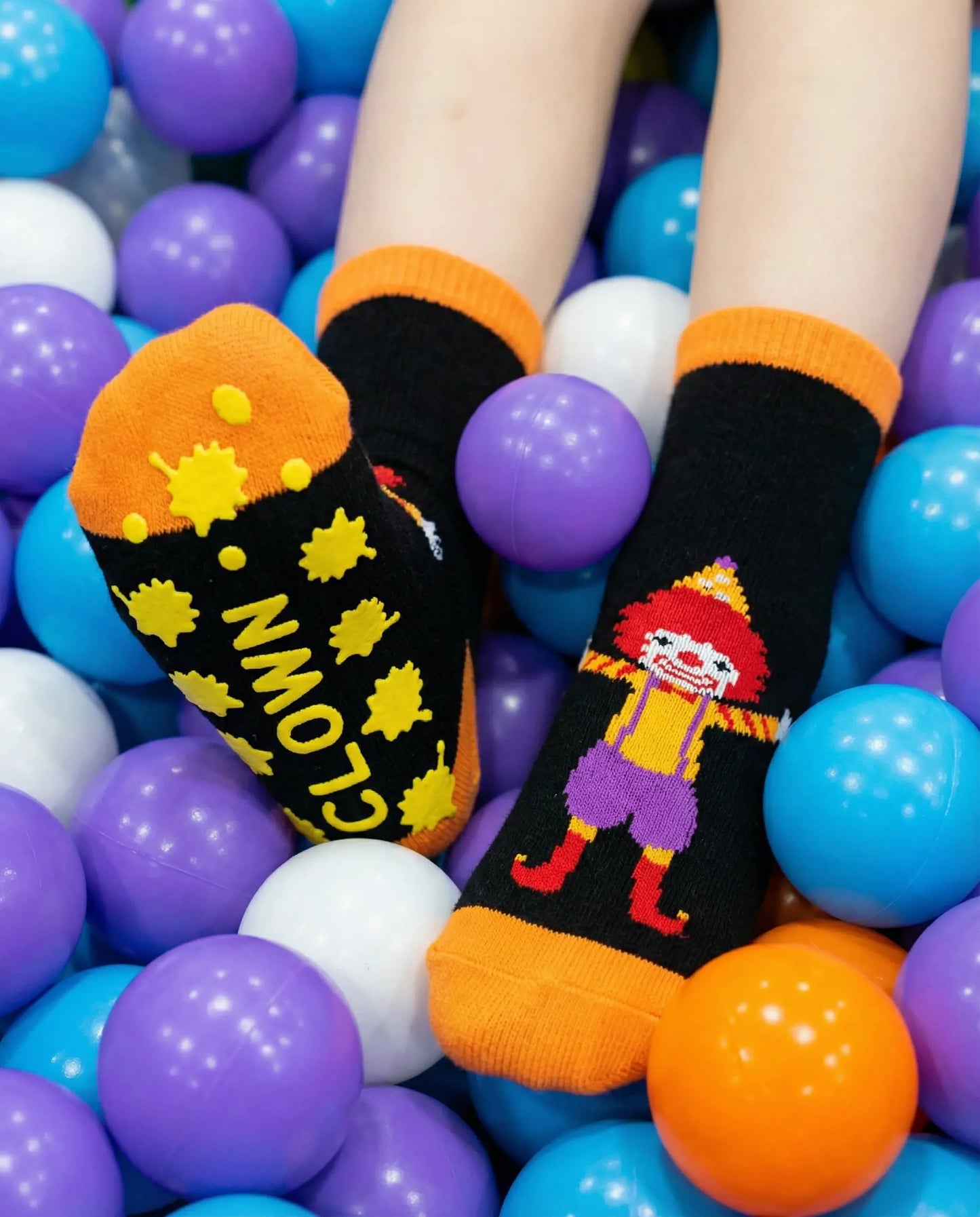 Tryon of silly clown family grip sock in orange colour in the ball pit