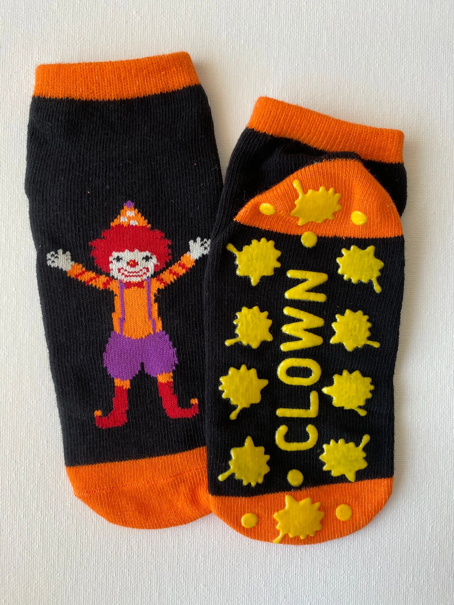 Silly clown family grip sock in orange colour macro detail of silicone dot pattern on sole
