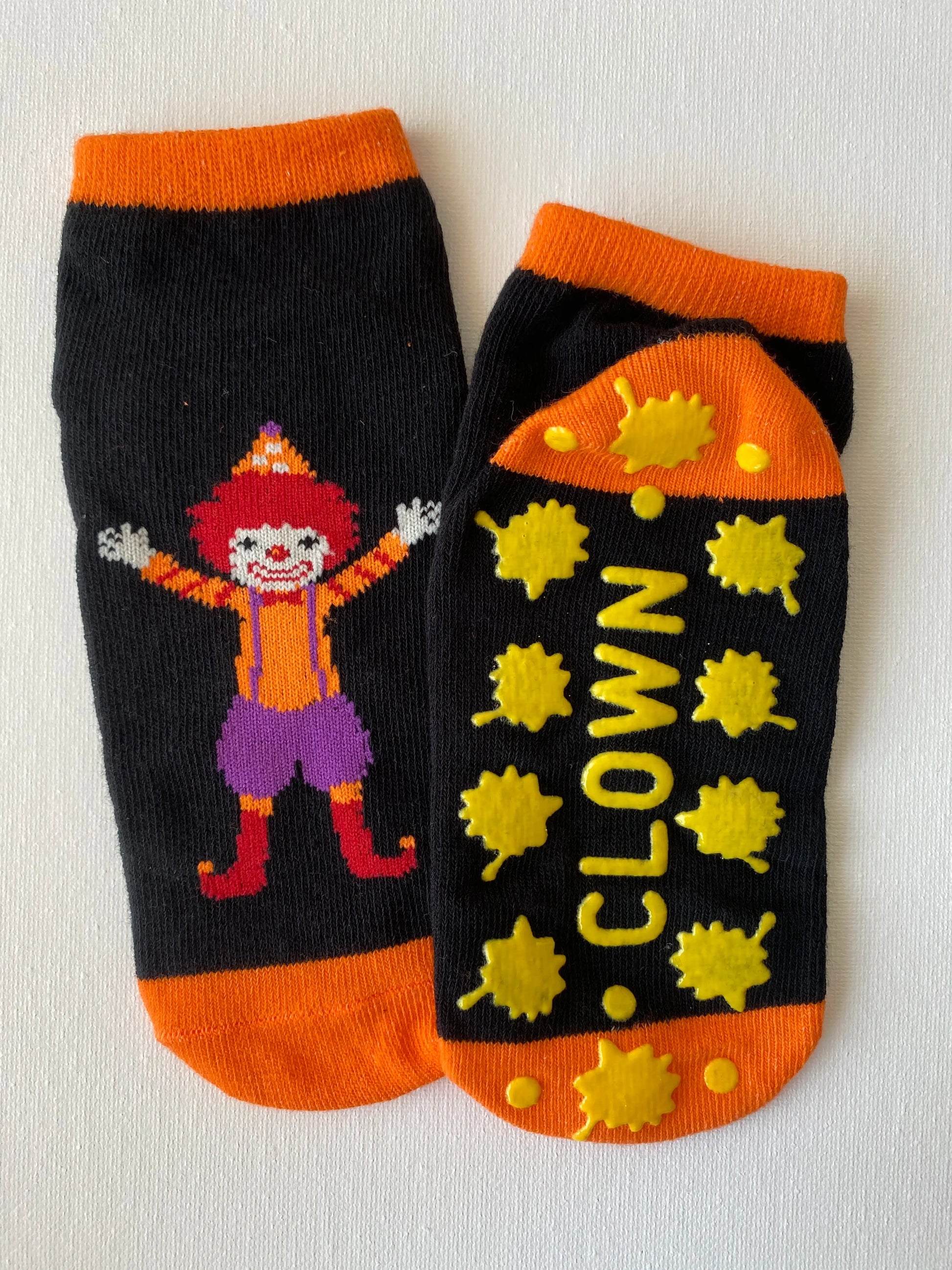 Silly clown family grip sock in orange colour macro detail of silicone dot pattern on sole