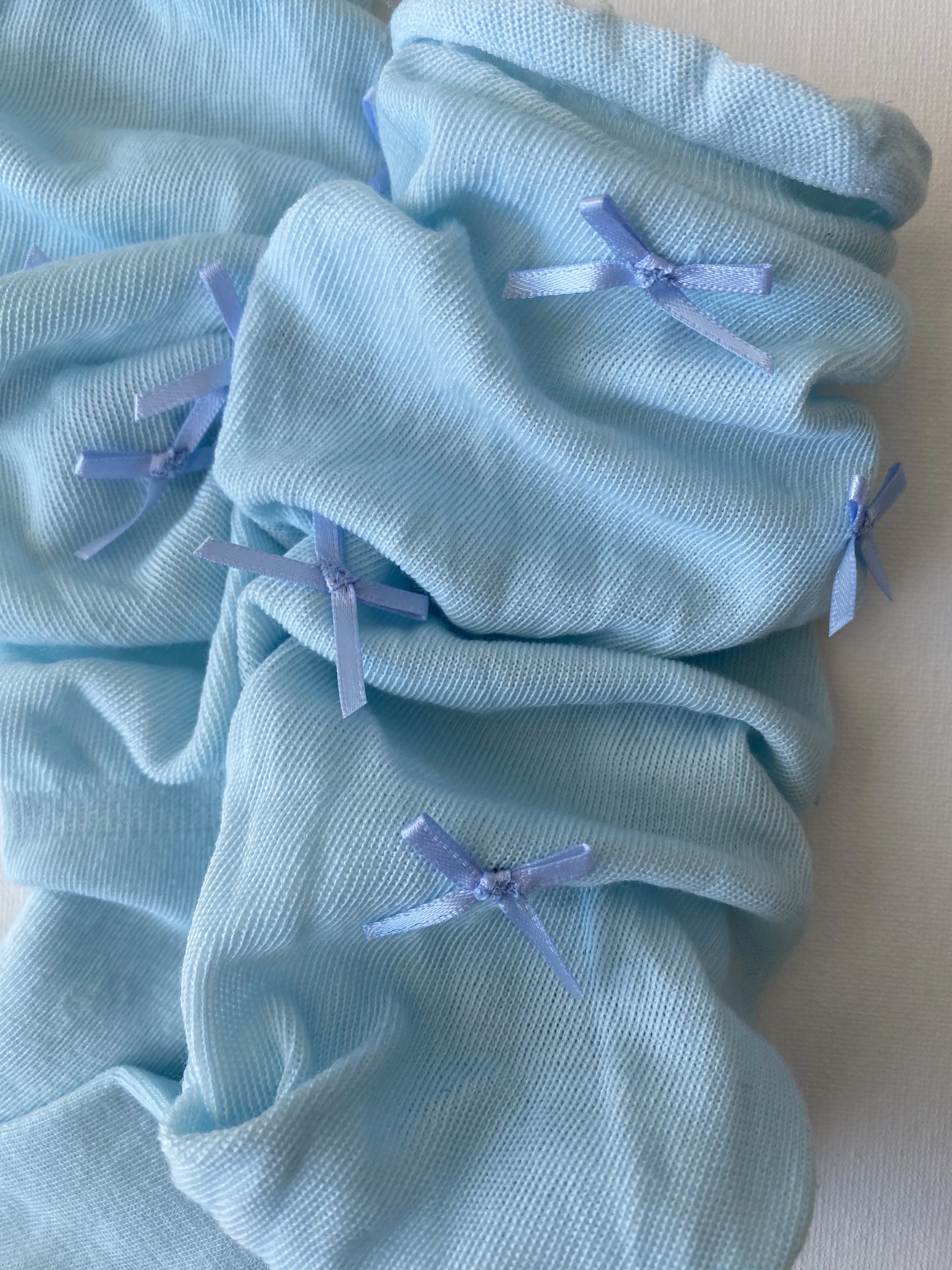 Closeup of slouched bow mid calf crew sock in dusty blue colour slouching leg details