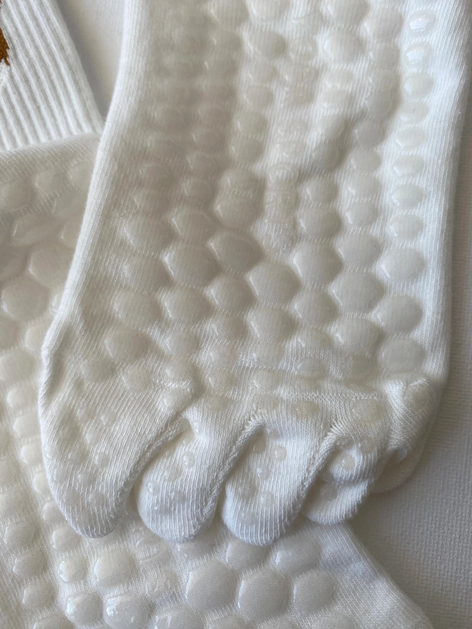Tiptoe animal grip toe sock white corgi macro detail of silicone dot pattern on sole